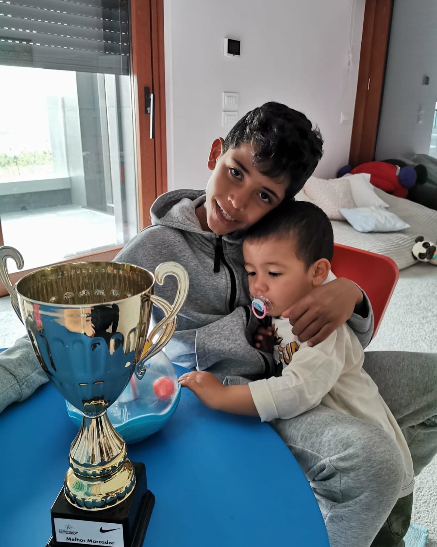 One sweet family snap showed Cristiano Jr hugging his younger sibling while proudly showing off a trophy