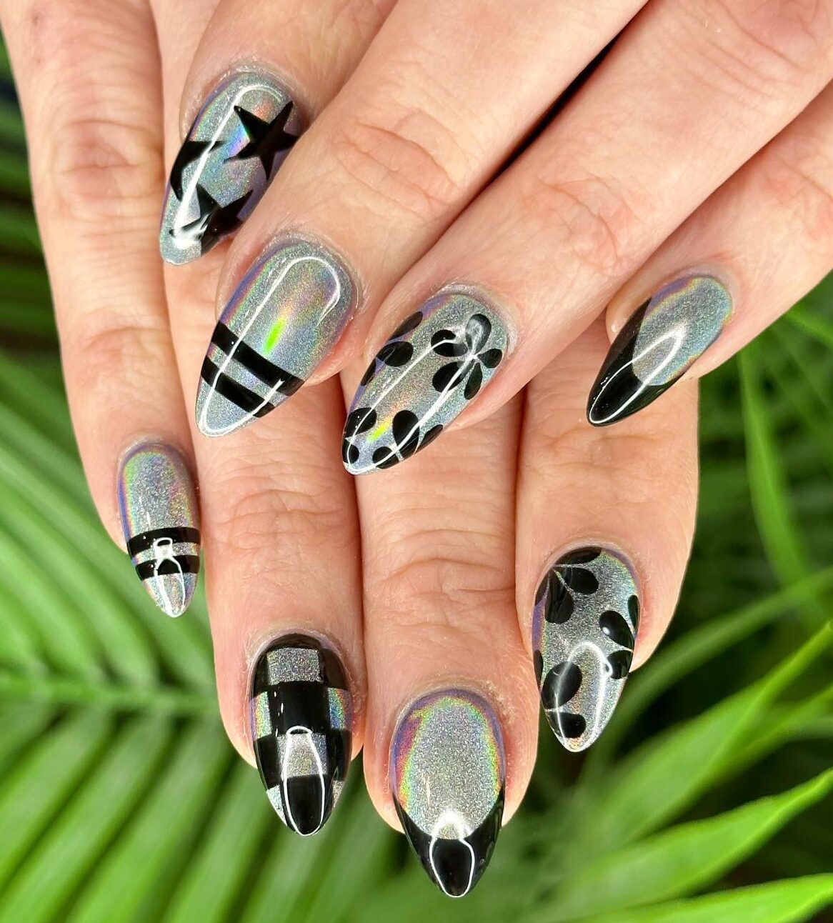 Silver chrome nail polish with black nail designs on long almond nails