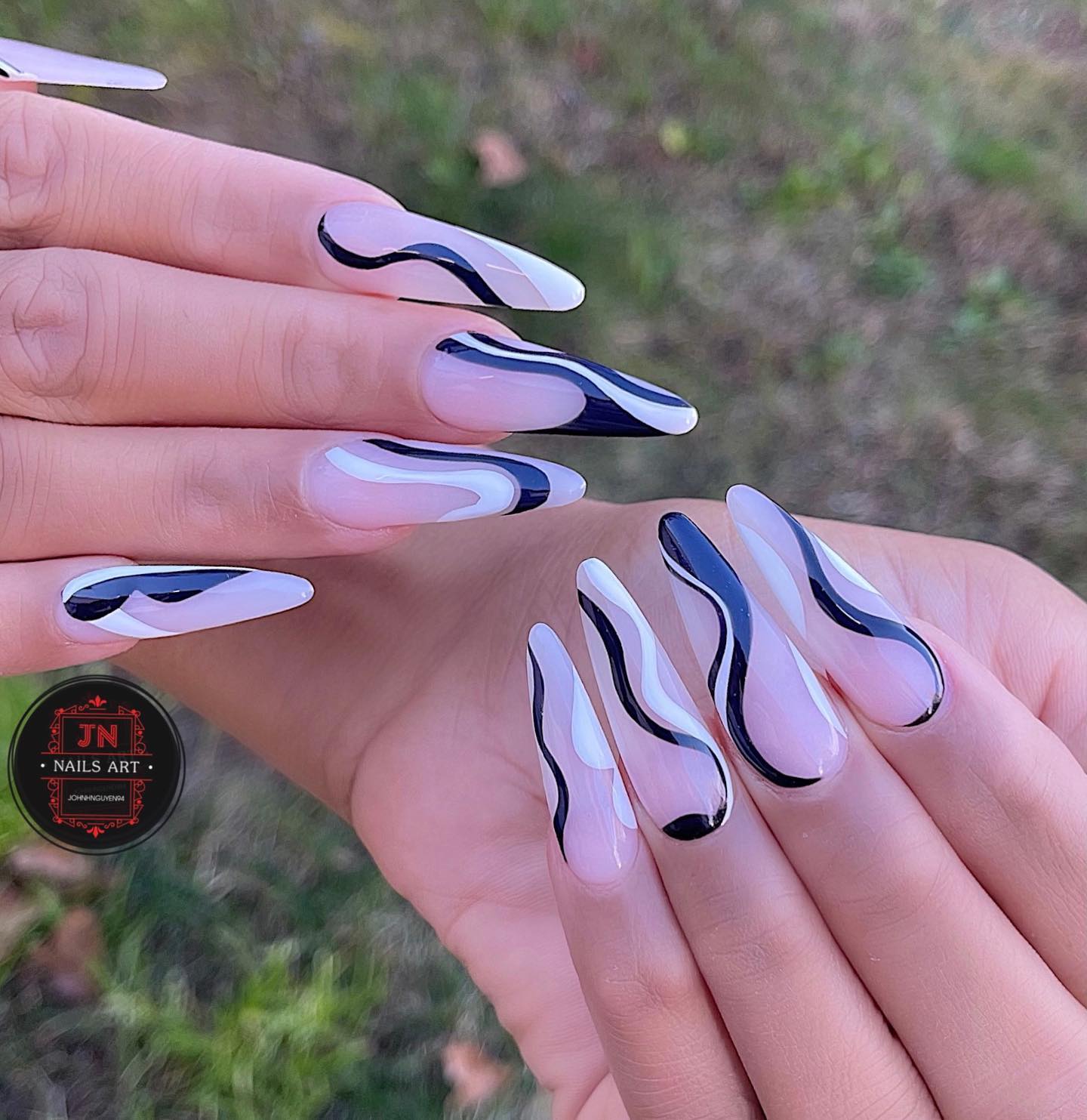 Clear stiletto nails with black and white swirls