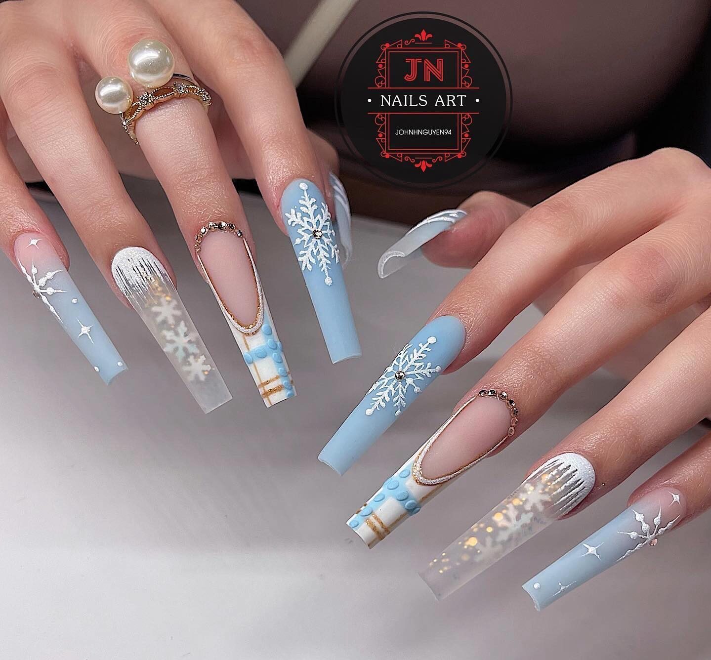 Light blue and clear nail colors with snowflakes and glitters nail arts on super long tapered square nails