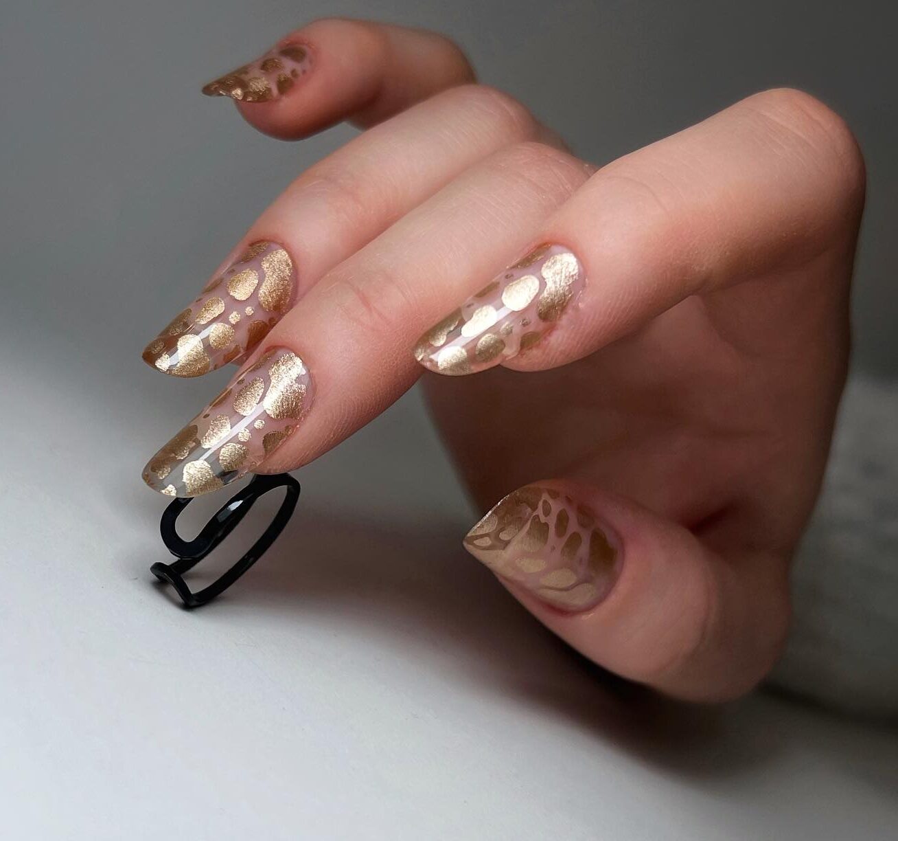 Long round shaped clear nails with gold abstract nail design