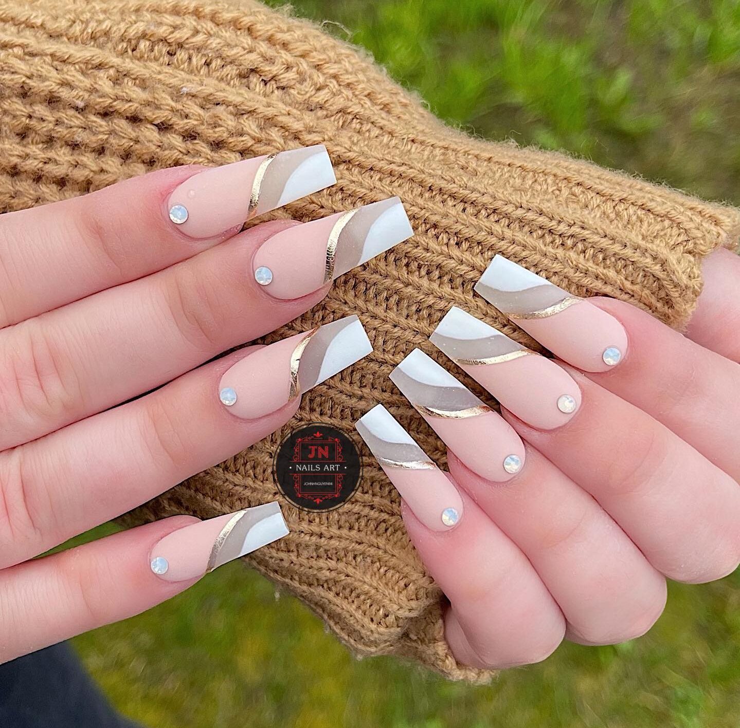 Matte finish nude, white, and clear coffin nails with rhinestones