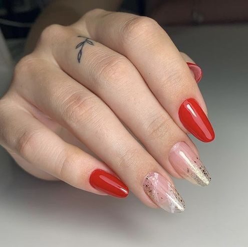 Vibrant red and clear round nails with gold glitters