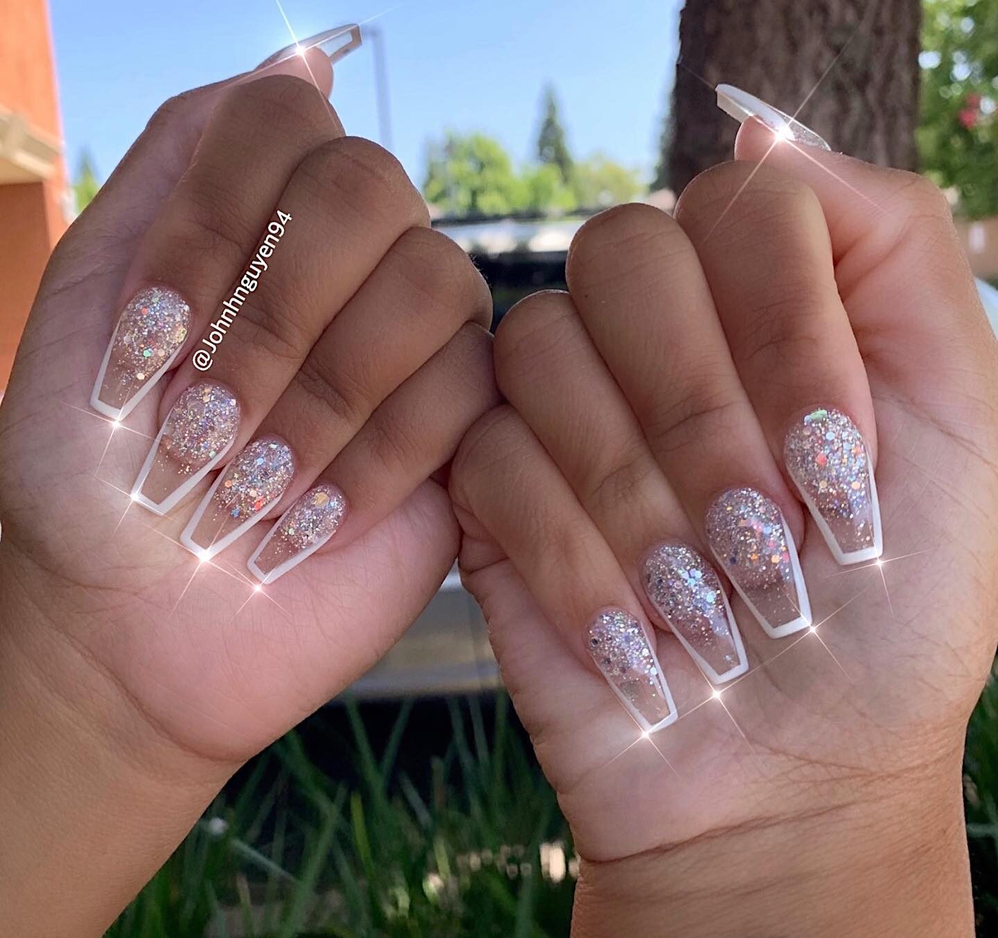 Long coffin shaped clear nails with sparkling glitters and white thin French tips