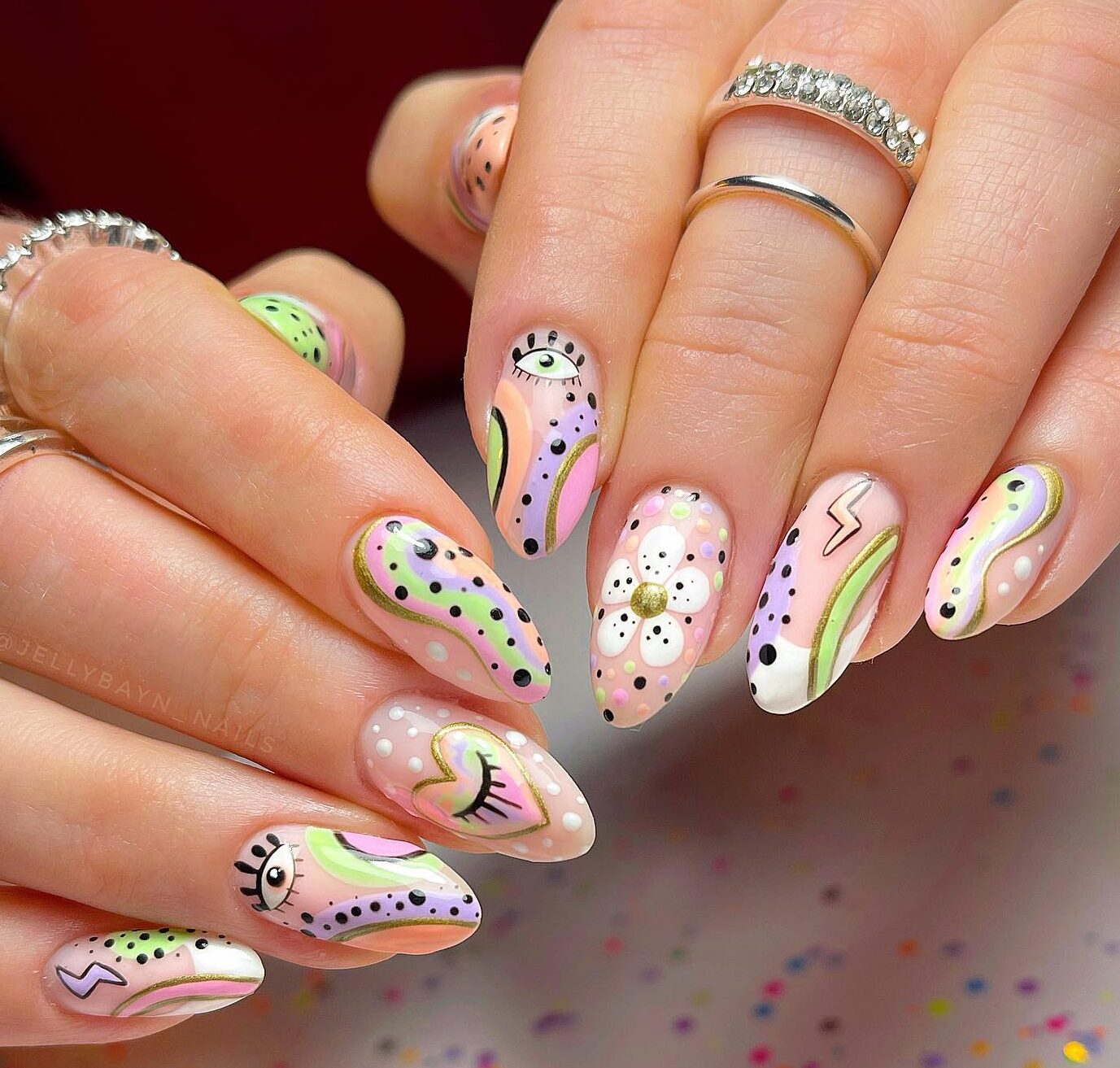 Pastel colored swirls, evil eyes nail art, flowers, and black polka dots on medium almond nails