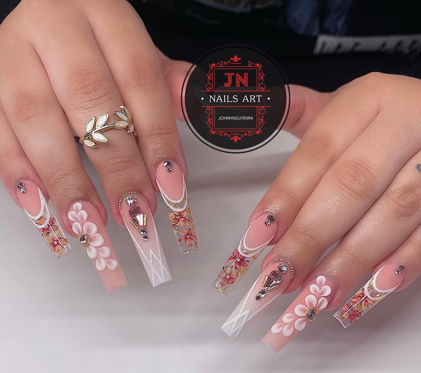 Combination of nude and clear tapered square nails with flowers and gems nail arts