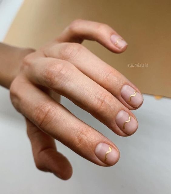 Short natural clear nails with gold wavy line accents