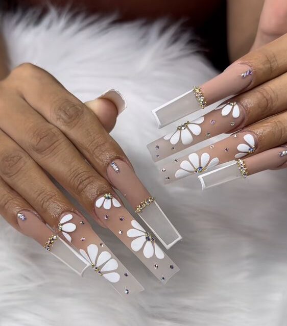 Nude to clear ombre effect with thin French tips, rhinestones, and flowers nail designs on super long square nails