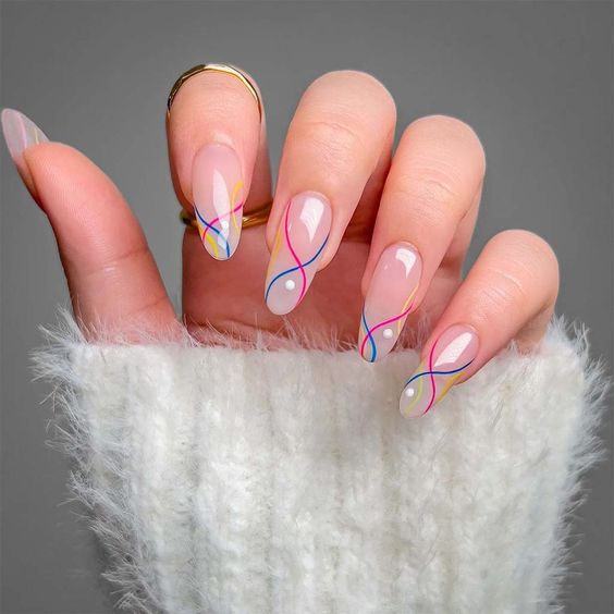 Clear round nails with yellow, pink, and blue swirling patterns