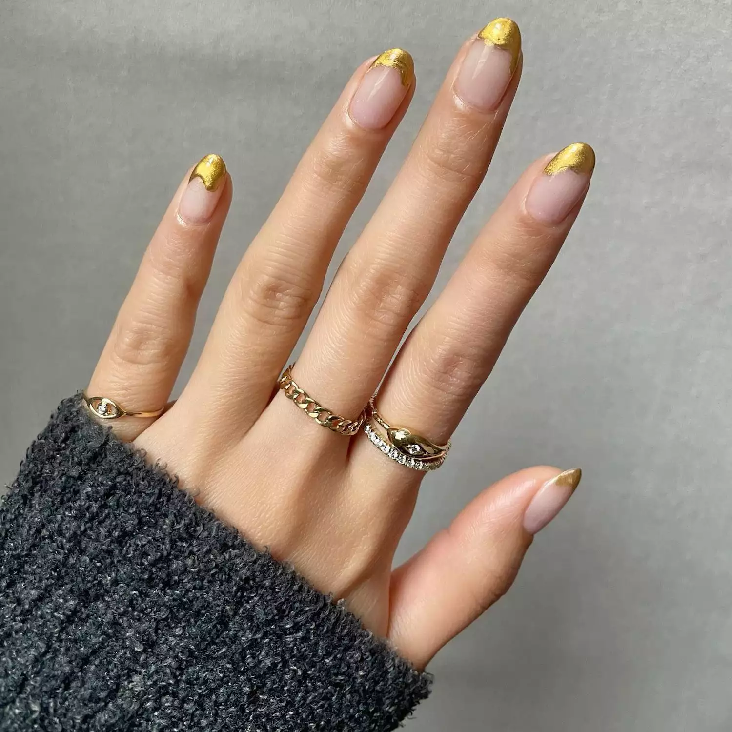 Manicure with clear base and golden chrome drip tip design