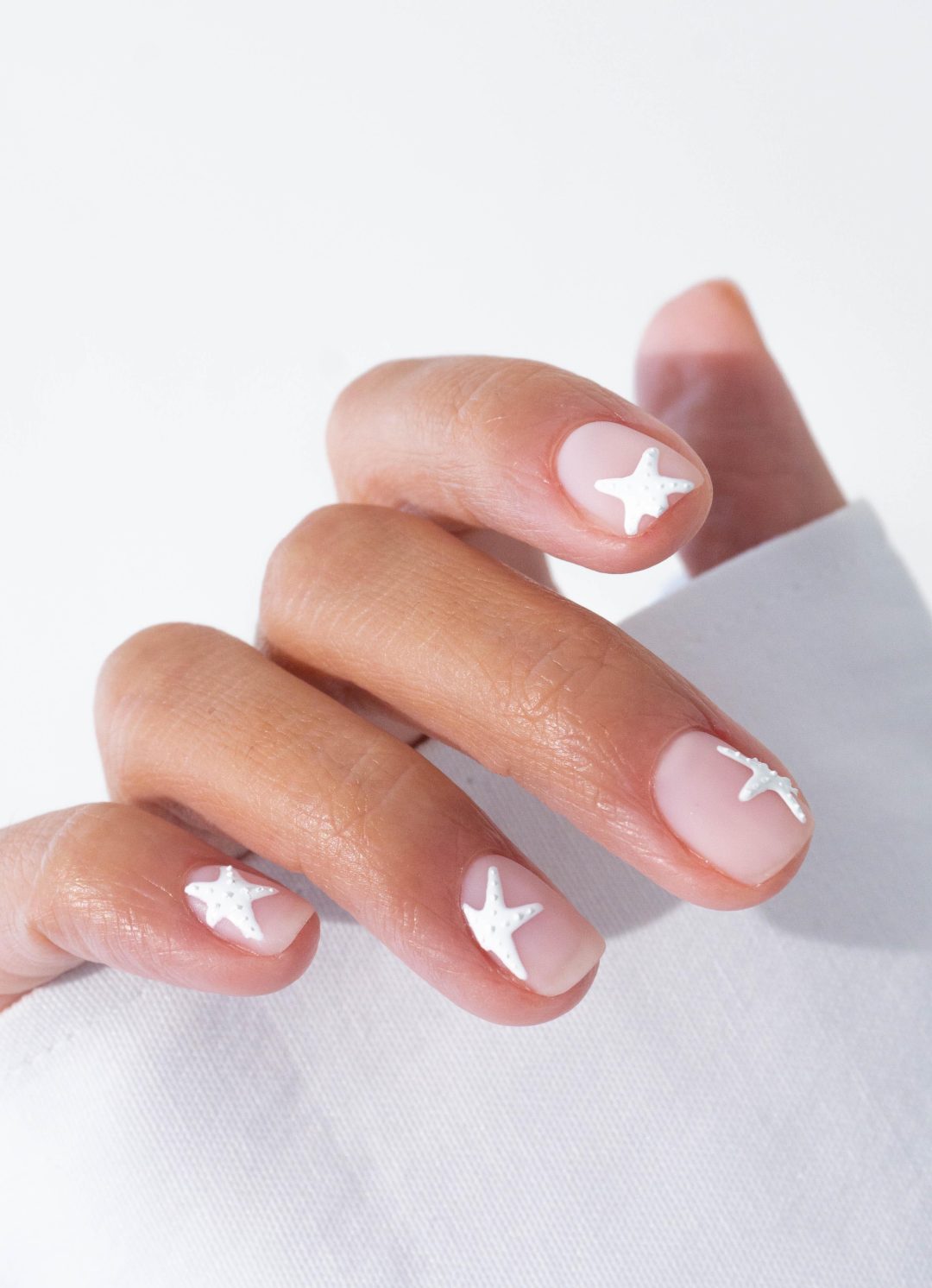 White starfish nail art on short clear nails.