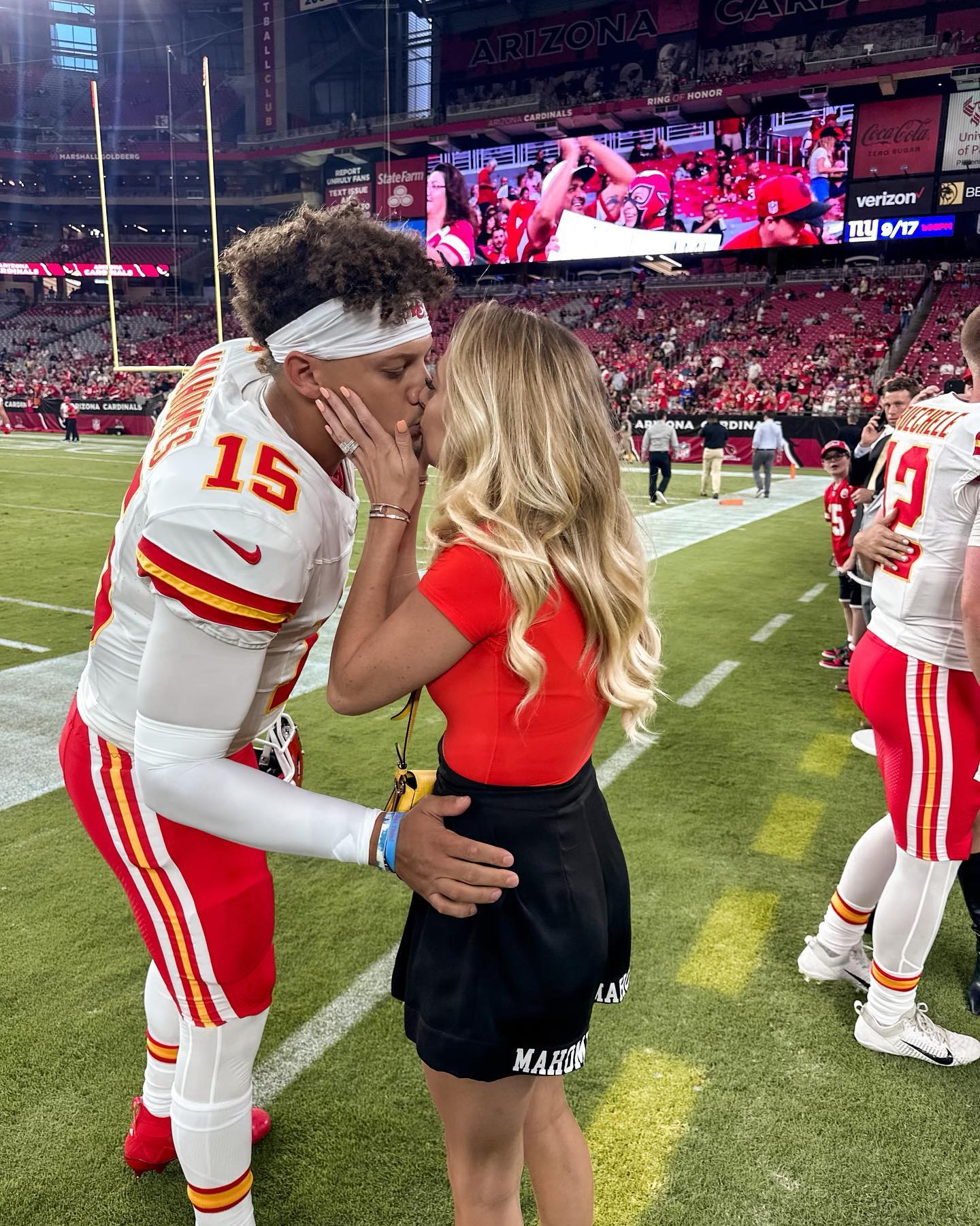 Brittany Mahomes kissing Patrick Mahomes.