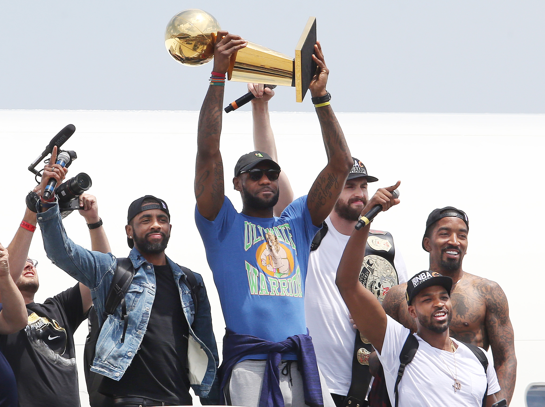 Cleveland Cavaliers' LeBron James holds up the championship trophy with teammates Kyrie Irving (L-R) Kevin Love, JR Smith and Tristan Thompson for the fans that packed the IX Center at Cleveland Hopkins Airport on the team's return home, June 20, 2016.    John Kuntz, cleveland.com