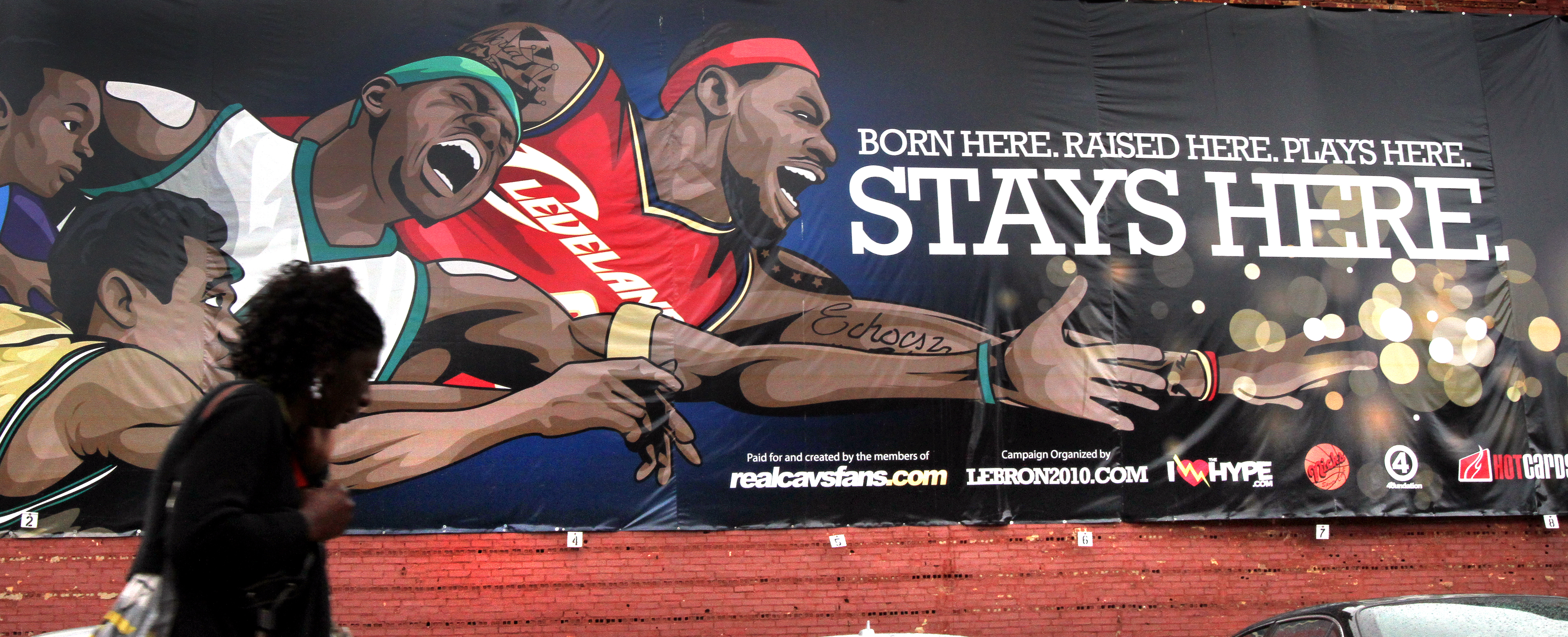 A pedestrian hardly acknowledges a sign on the side of Nick's Sports Corner on Prospect Ave. in downtown Cleveland, Ohio, the day after LeBron James announced that he will play in Miami next season instead of with the Cavaliers, on Friday, July 8, 2010.  The sign states,