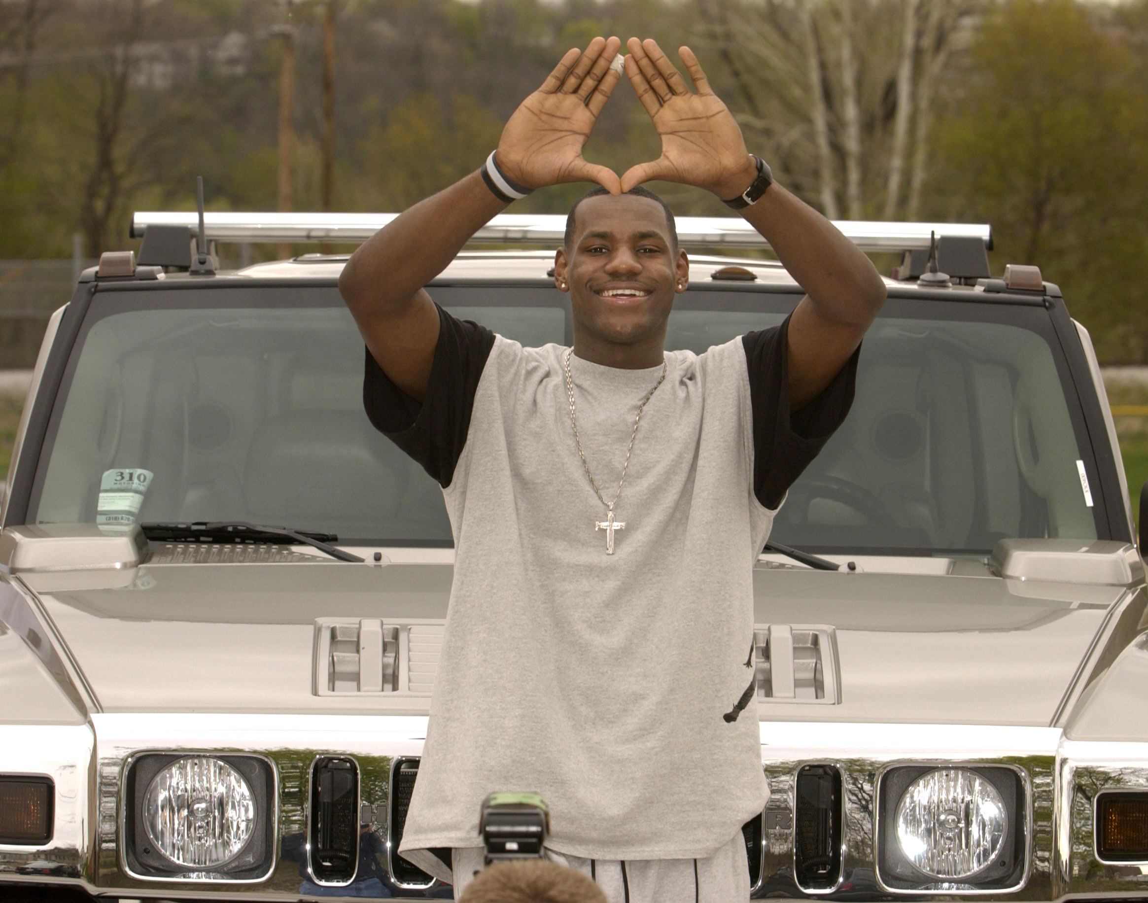 LeBron James poses for photographers with his Hummer after his press conference Friday afternoon in Akron.   FRIDAY  APRIL 25, 2003  (BILL KENNEDY/PLAIN DEALER)